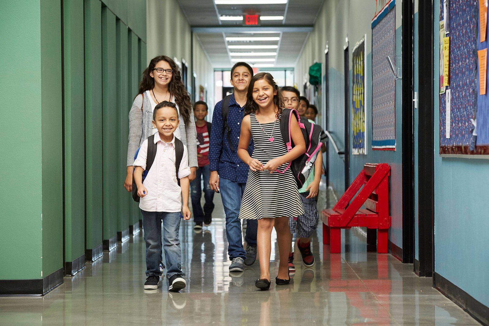 who-we-are students walking in a school hallway