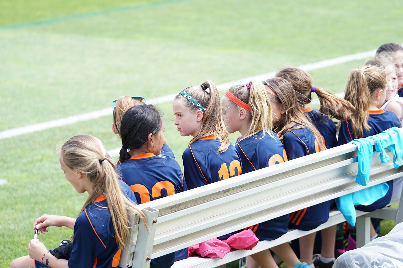 jeffrey-f-lin-ymVaGKsBQXM-unsplash An elementary school girl's soccer team sitting on a bench